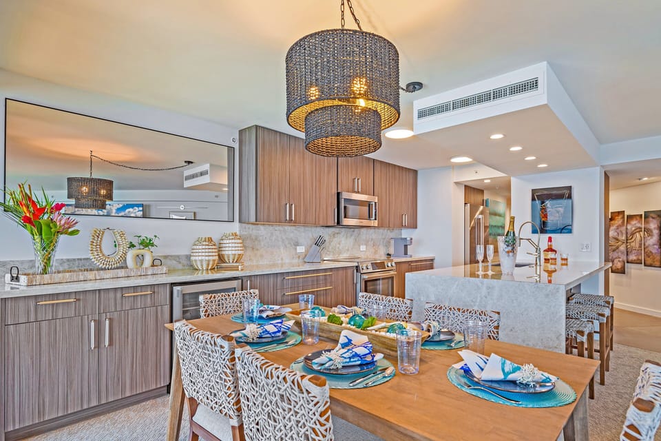 Enjoy meals in this stylish dining area featuring a chic chandelier and easy access to the modern kitchen