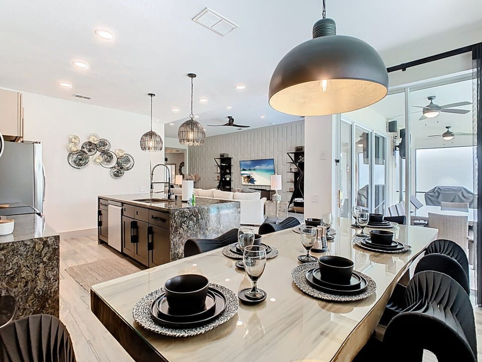 Bright open-concept layout featuring a modern kitchen, stylish dining setup, and a relaxing living area—perfect for gathering and entertaining.
