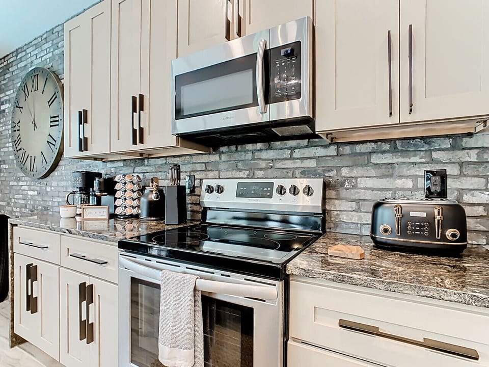 Stylish and functional kitchen with premium appliances, chic backsplash, and everything you need for a convenient stay.