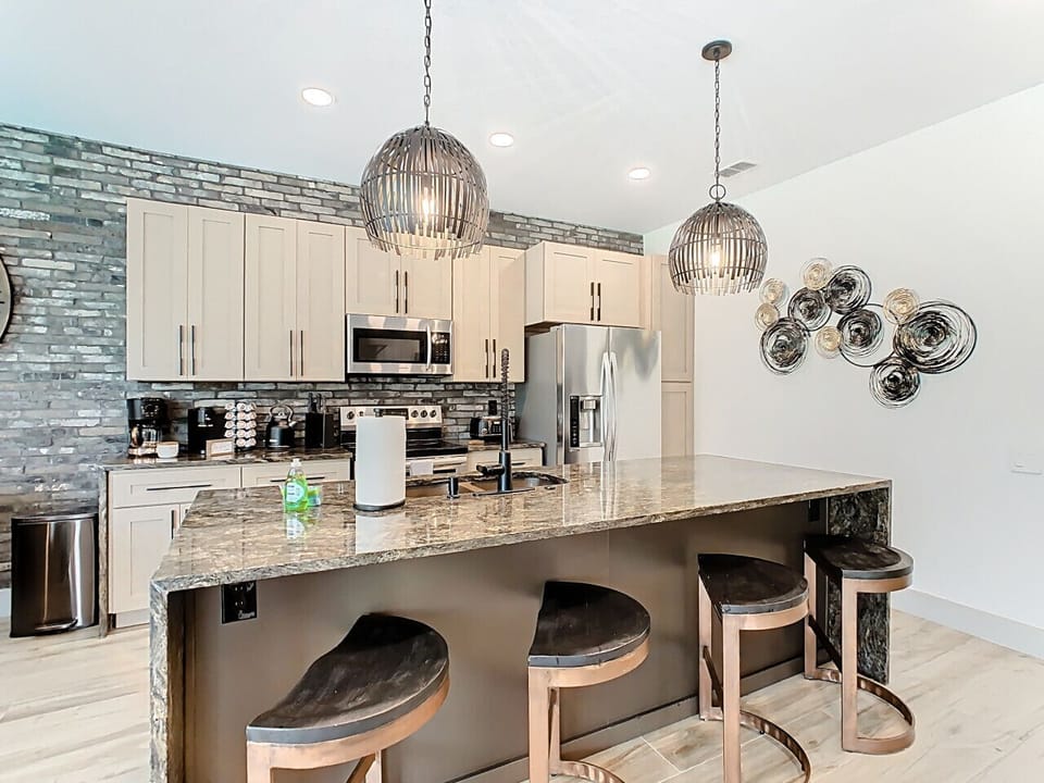 Fully equipped modern kitchen with premium appliances, stylish backsplash, and a generous island perfect for meal prep or casual dining.
