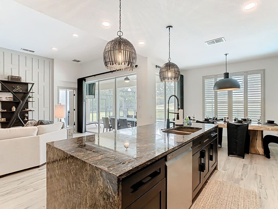 Open-concept living and dining area with elegant lighting and direct access to the outdoor patio.