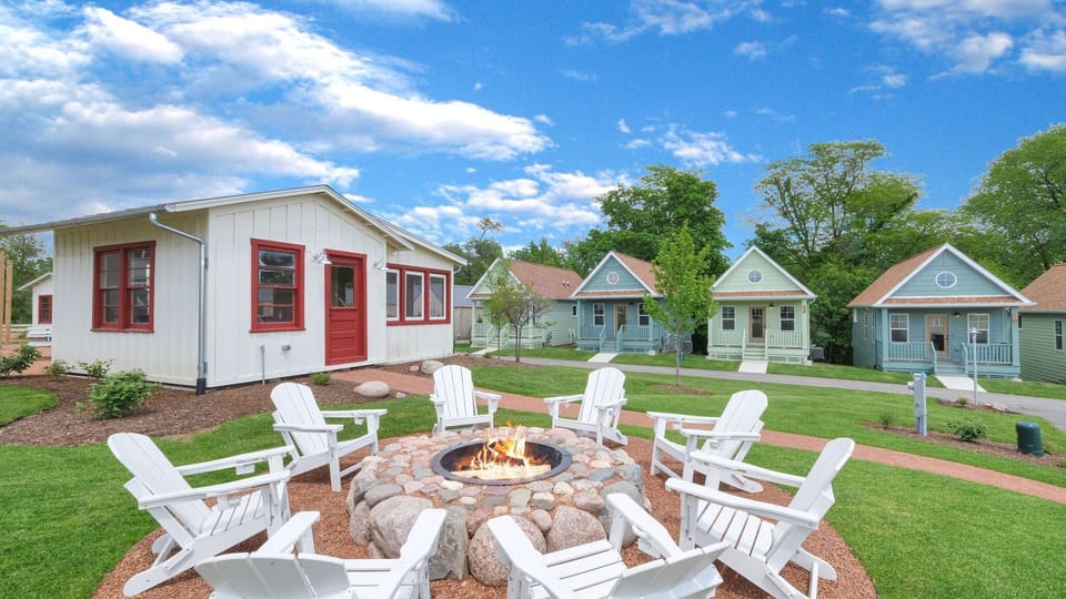 A charming tiny house village with colorful cottages and shared fire pit perfect for evening gatherings under the open sky.