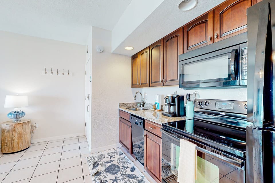 Prepare meals with ease during your beach stay in this fully equipped kitchen featuring modern appliances, ample counter space, and coastal accents—perfect for breakfast before the beach or dinner after a day in the sun.