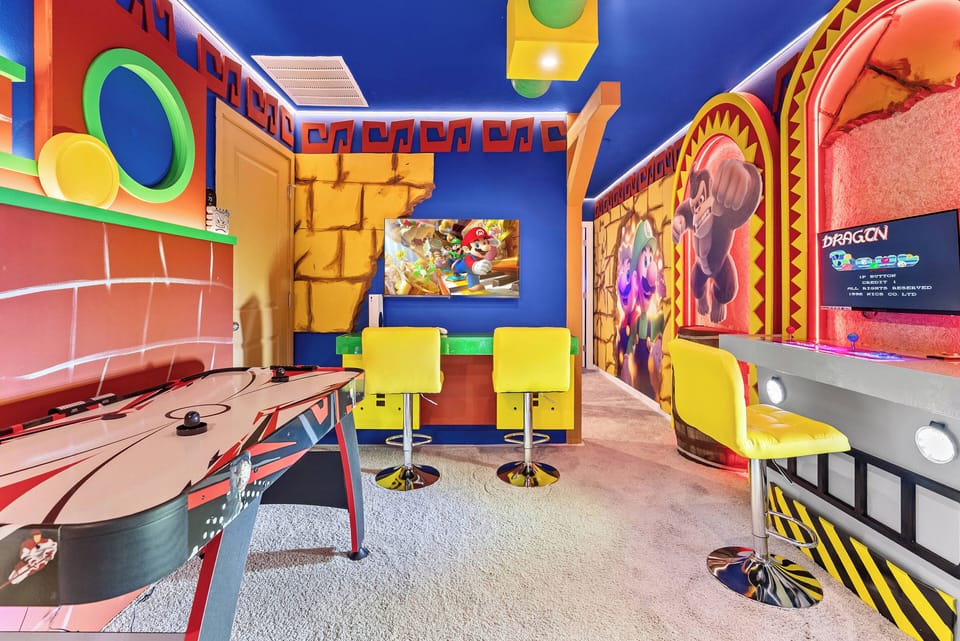 Discover a lively game room brimming with color, featuring a sleek air hockey table and cheerful yellow seating. The bold blue walls and themed artwork set the stage for unforgettable fun-filled evenings.