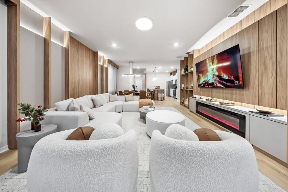 Enjoy a spacious living area with plush cream sofas that invite relaxation, warm wooden accents, and soft lighting. The sleek entertainment center adds a cozy, stylish touch, perfect for unwinding after a day of exploration.