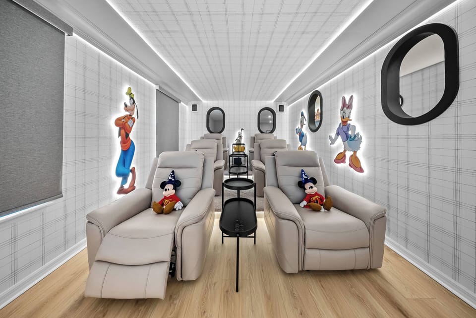 Experience entertainment in this cozy home theater, featuring plush reclining seats that invite relaxation. Bright, playful wall art adds a whimsical touch, while sleek lighting enhances the inviting atmosphere for movie nights.