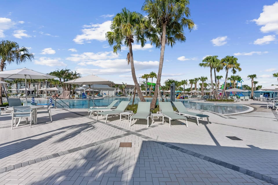 Step outside to enjoy a beautiful pool area with swaying palm trees and clear blue skies. Relax on the spacious deck with comfortable lounge chairs, or take a refreshing dip in the inviting water. It's the perfect spot to unwind.