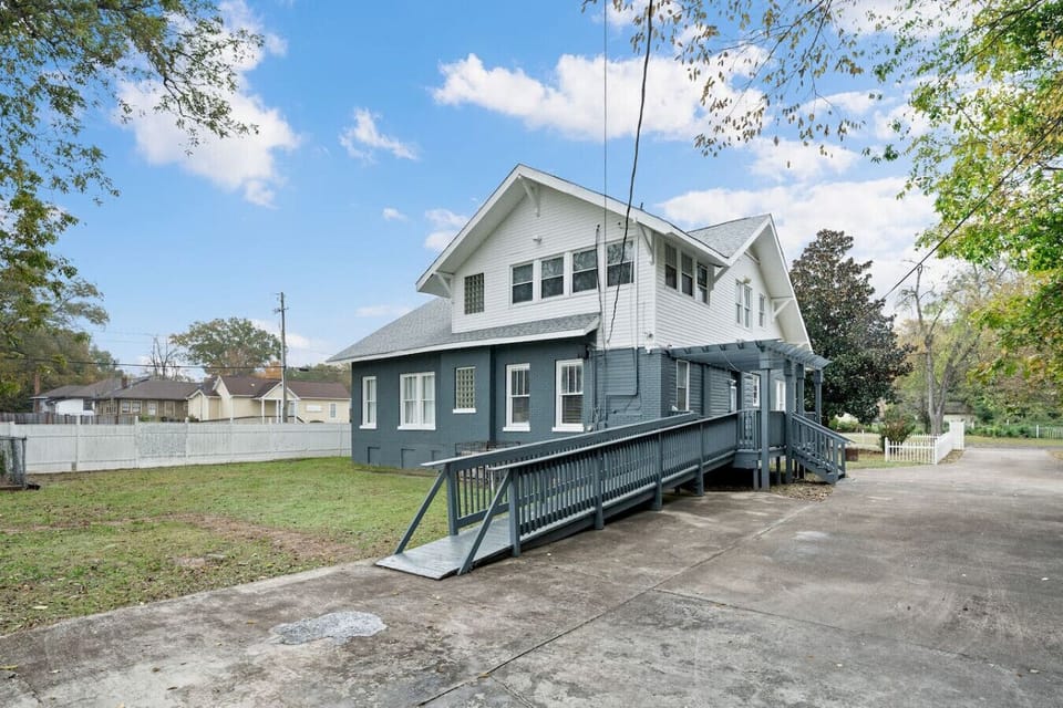 Back exterior photo of the home with its wide backyard.