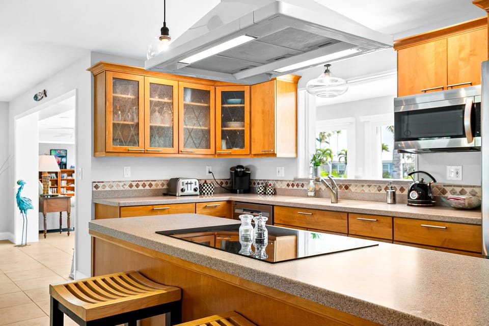 Your gourmet kitchen awaits with warm wood cabinetry, granite countertops, and a spacious island perfect for cooking and entertaining. Natural light floods the space through bright windows, creating an inviting atmosphere for your culinary adventures.
