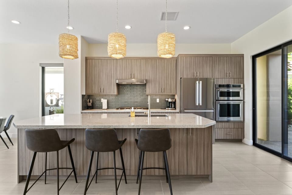 Spacious kitchen island w/ bar seating, pendant lighting & sleek modern cabinetry