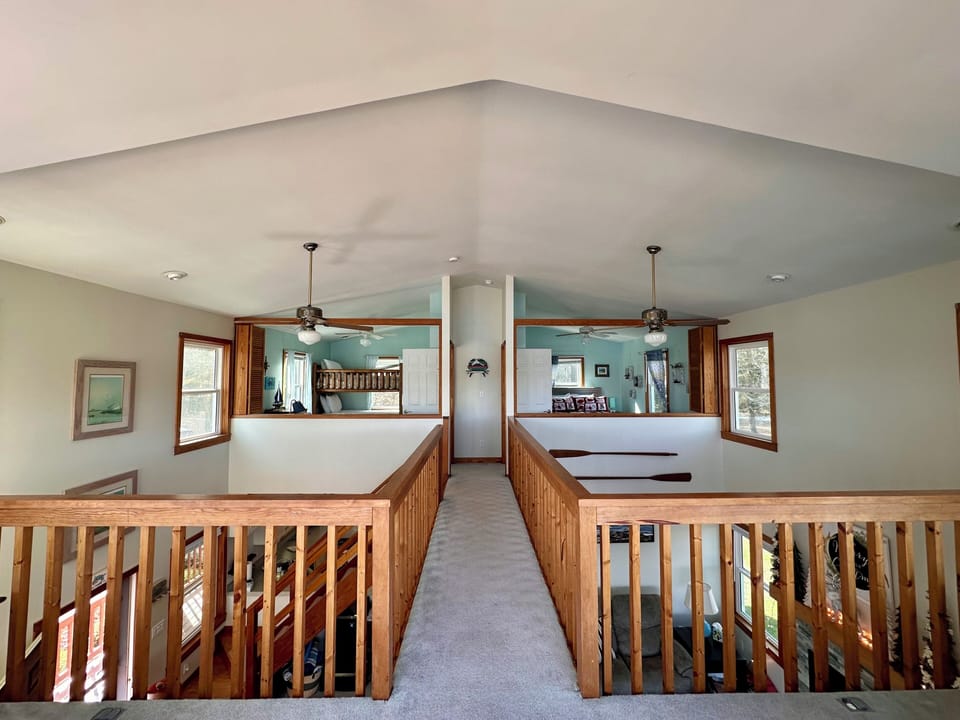 Open upstairs looking into bedroom, rooms have shutters for privacy