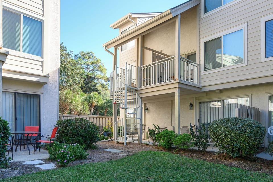 View of outdoor balcony with staircase to private courtyard and pool 
