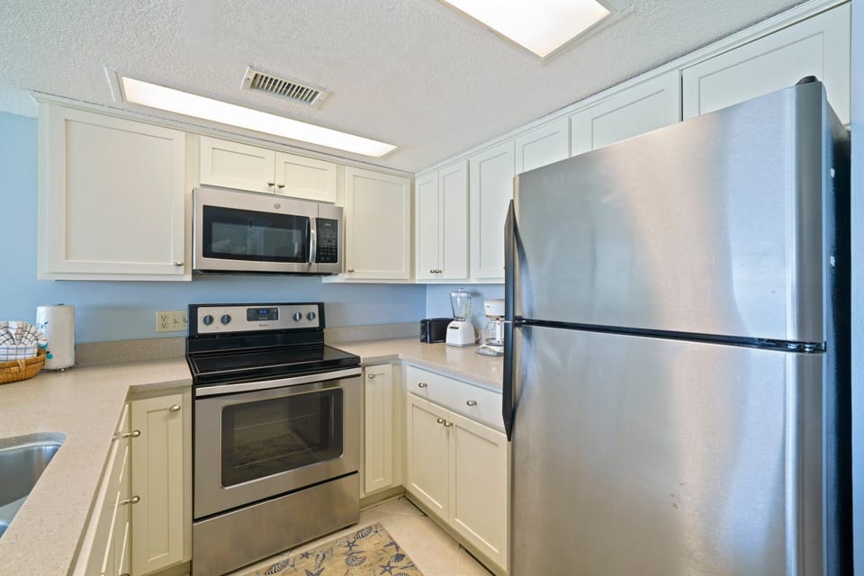 Cabana Club 203 boasts a beautifully updated kitchen with stainless dishwasher, ample counter space, and seating for family gatherings.