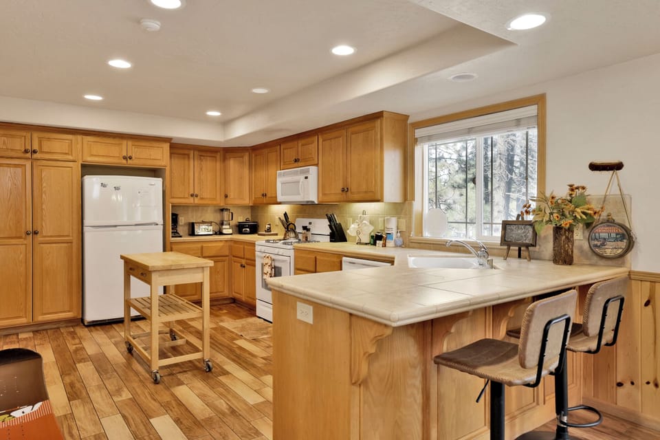 Bright culinary space with island seating and sleek modern cabinetry, offering a stylish and functional kitchen for gatherings and gourmet meals