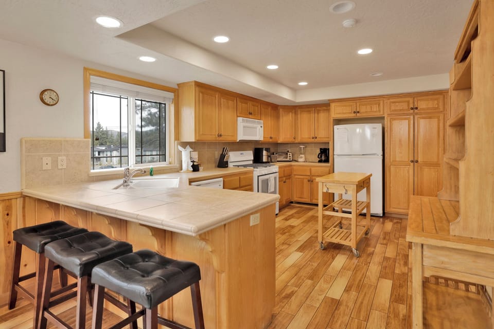 Fully equipped cabin kitchen with ample cabinetry, stove, fridge, microwave, and coffee maker—perfect for cooking meals, morning coffee, and feeling right at home on your stay.