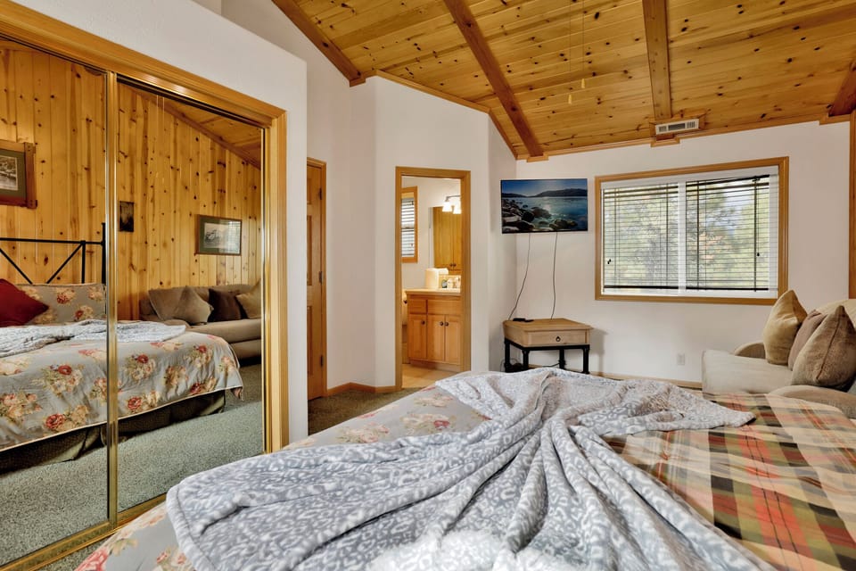 Peaceful cabin bedroom with plush bedding, and beautiful views—ideal for restful nights, cozy mornings, and a relaxing mountain escape.