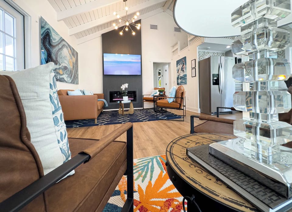“Elegant living area with a sleek fireplace, 65'' smart TV, and a premium leather sectional. The expanded sitting room next door offers additional lounging space for groups.”