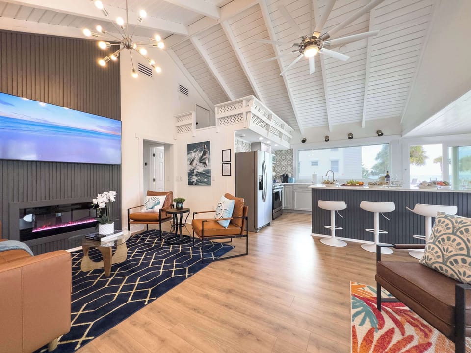 “Elegant living area with a sleek fireplace, 65'' smart TV, and a premium leather sectional. The expanded sitting room next door offers additional lounging space for groups.”