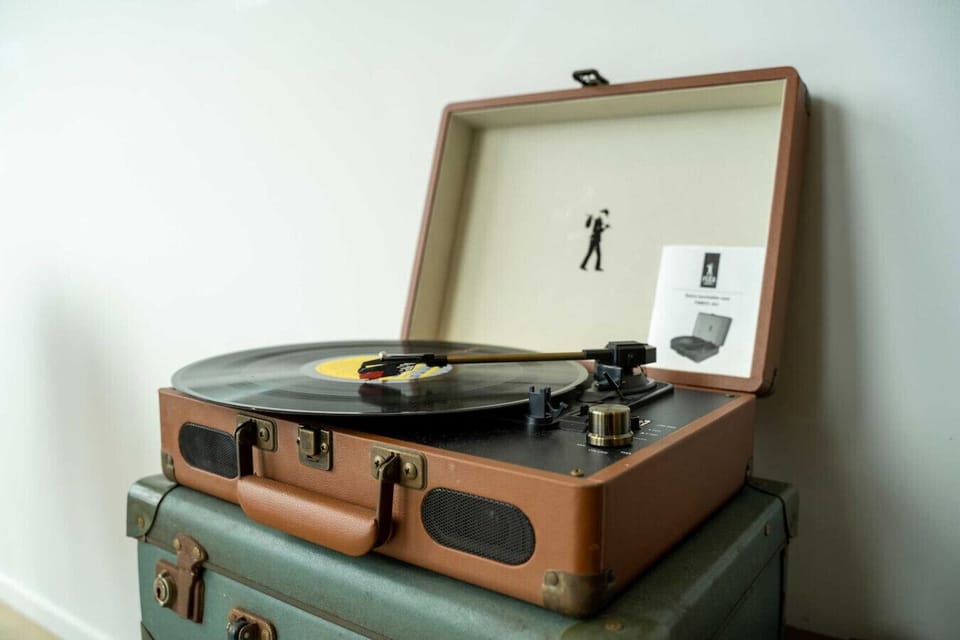 A vintage suitcase turntable with a vinyl record ready to play — a charming in-home touch that sets the mood for a relaxed evening in. Put on a record and let the city views do the rest.