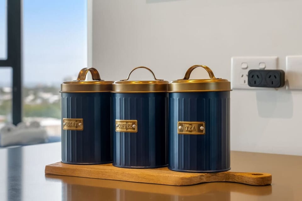 Sugar, coffee, and tea canisters ready on the kitchen counter, with city views through the window - a nice little touch for guests settling in and making themselves at home.
