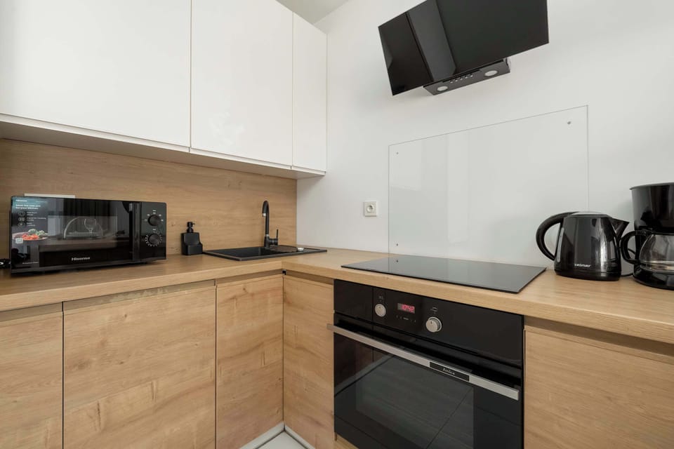 Modern kitchen with built-in appliances, wooden cabinetry, and minimalist design.