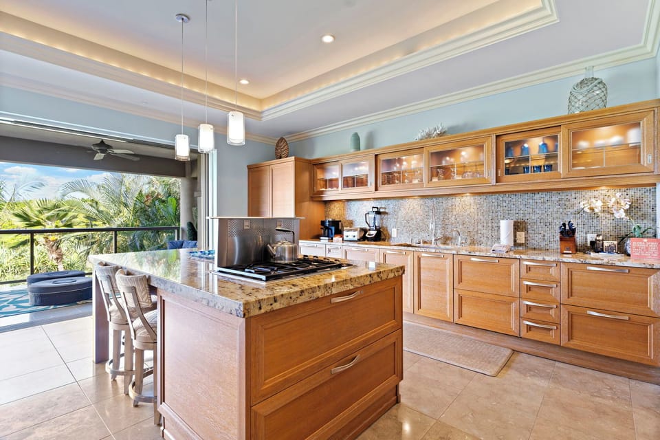 A spacious kitchen featuring granite countertops, rich cabinetry, and a central island