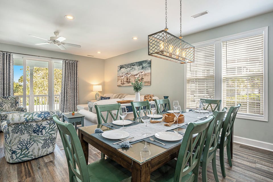 This open dining and living space is filled with natural light and fresh coastal style—perfect for relaxing together.
