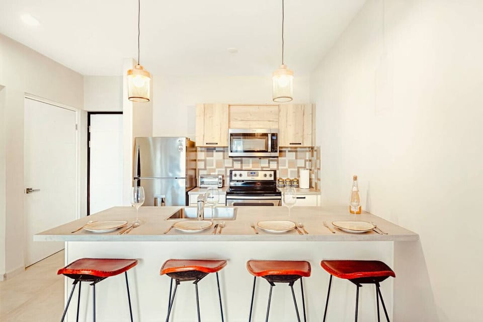 A bright, fully equipped kitchen with a welcoming island—perfect for easy breakfasts, shared meals, or a relaxed evening drink together.