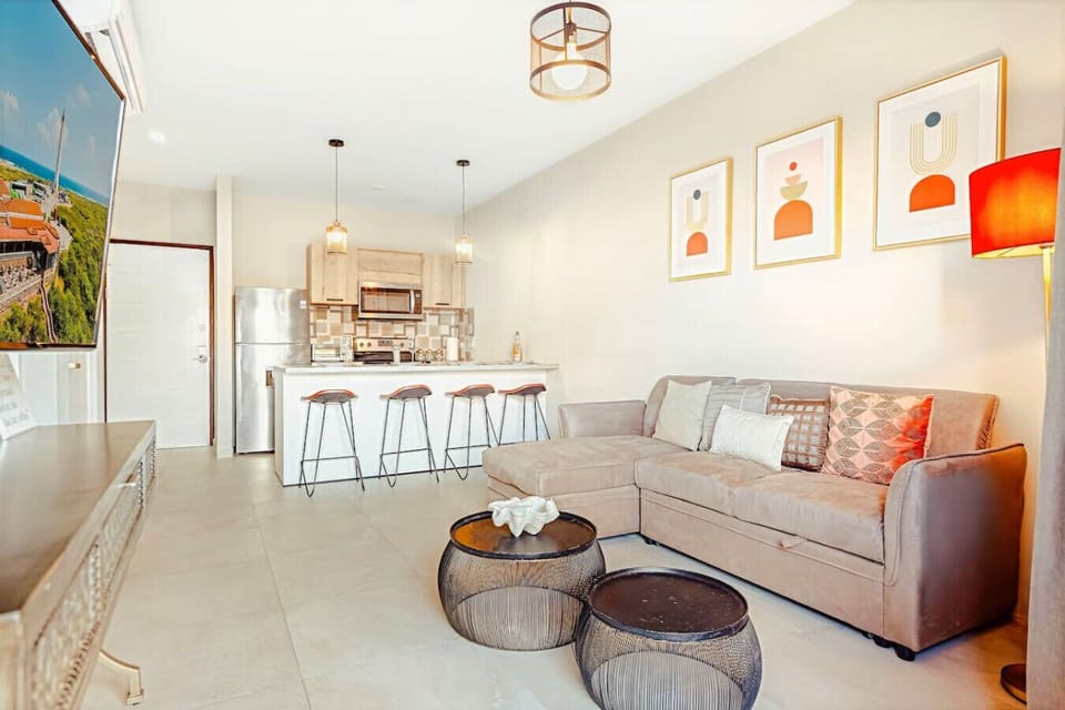 A cozy, open-plan living area with a comfortable sofa and fully equipped kitchen—perfect for relaxing, sharing meals, and feeling right at home during your stay.