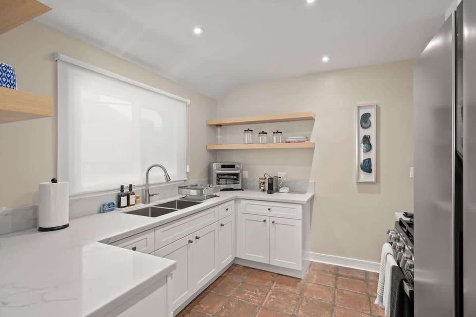 A bright Kitchen: Open shelving for easy to find items and storage. New stainless steel microwave and fridge! 