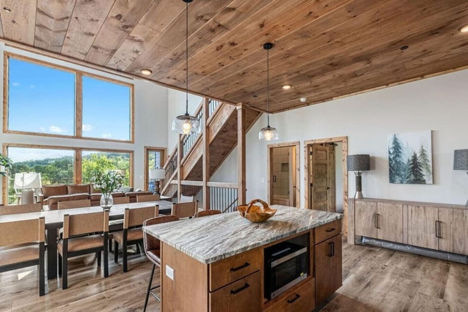 From the dining table to the cozy living area beyond, this open layout is made for shared moments. Big windows frame the mountains while the fireplace adds warmth and ambiance.