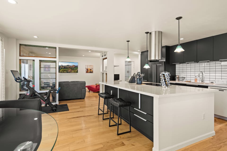 Your open-concept space blends modern style with everyday comfort, where the sleek kitchen island invites morning coffee while natural light fills the room through expansive windows.