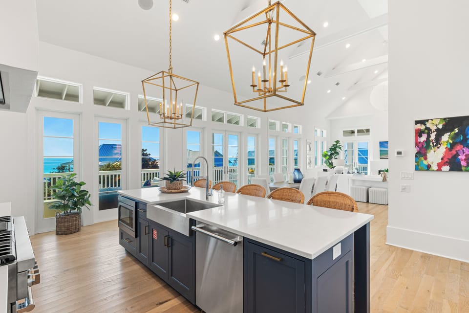 Gather around this stunning kitchen island where ocean views through floor-to-ceiling windows create the perfect backdrop for your morning coffee and memorable meals.