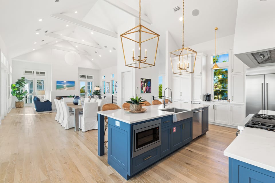 Your gourmet kitchen features a stunning blue island, premium appliances, and elegant pendant lighting for memorable meal prep.