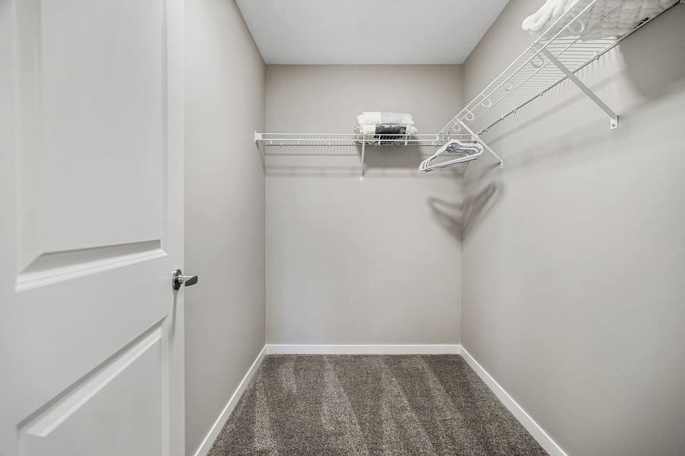 Primary bedroom, located upstairs, with a queen bed, Smart TV, room-darkening shades & a private ensuite full bathroom.