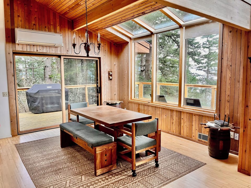 Bright dining area with forest and water views.