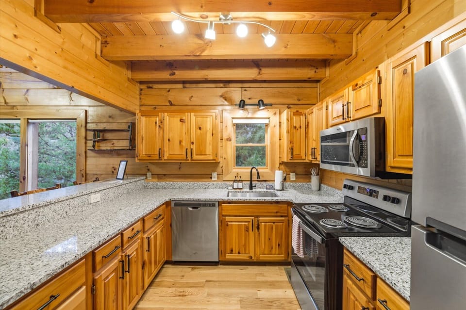 Amazing kitchen with granite counters, full supplies, and modern cabin charm.
