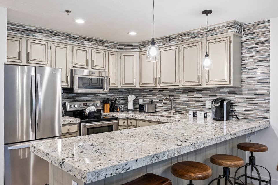 Beautifully remodeled kitchen with high-end granite countertops, stainless steel appliances, bar seating, and ample cabinet space. Ideal for cooking and gathering with friends and family.