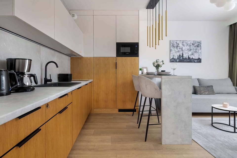 The bright kitchen with wooden cabinets and a sleek countertop provides everything needed for comfortable cooking during your stay.