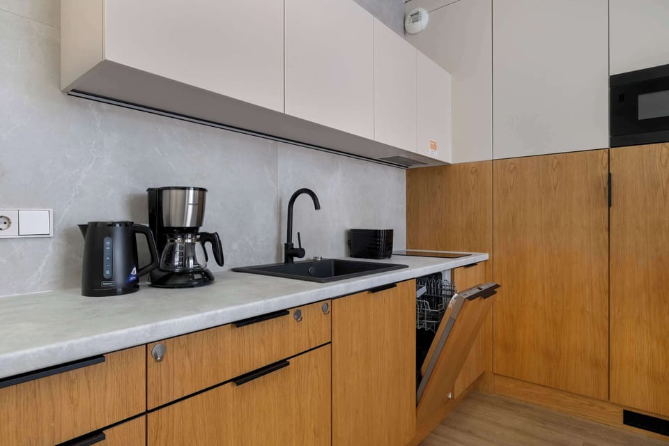 The fully equipped kitchenette with a coffee maker, kettle, and dishwasher offers home-like comfort even during a short stay.