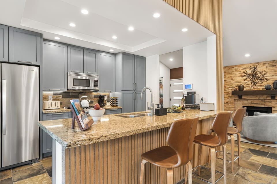 Kitchen features a barstool seating and modern appliances.