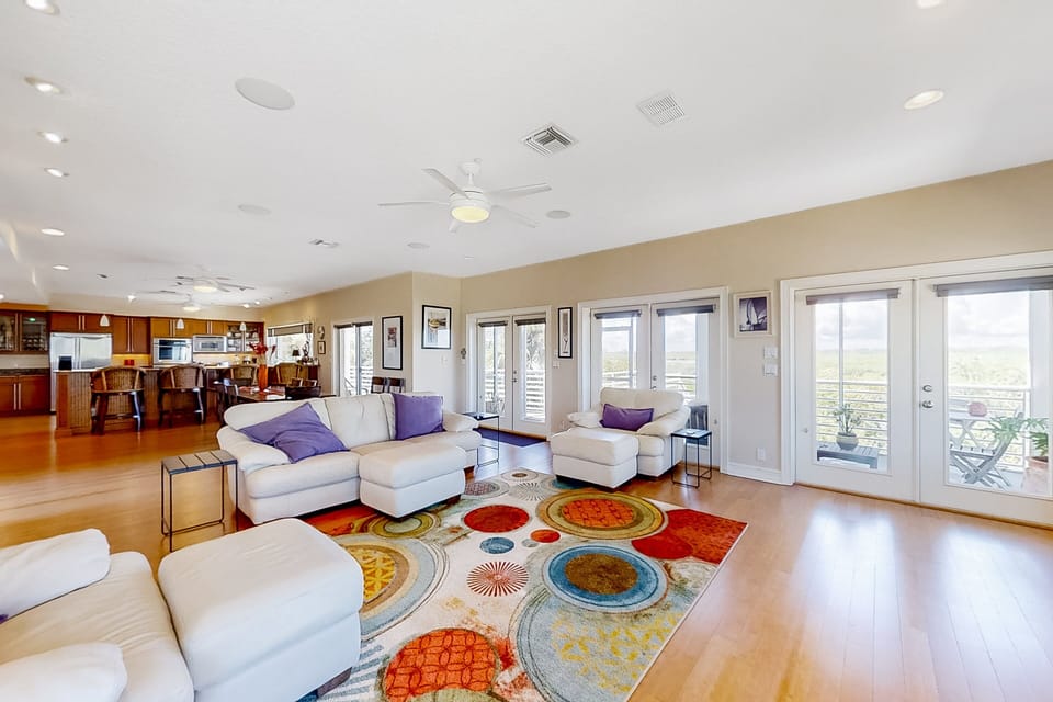 Settle into your beach stay in this bright, open living space featuring comfortable seating, abundant natural light, and multiple doors to breezy balconies—ideal for relaxing and entertaining after a day at the beach.
