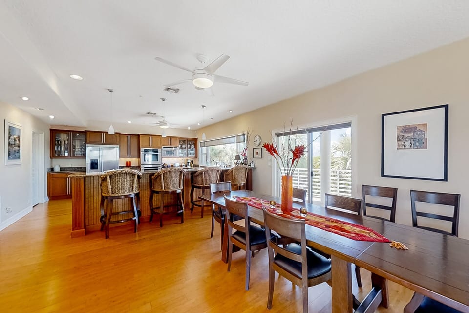 Gather and dine during your beach stay in this open-concept dining and kitchen space, featuring ample seating, natural light, and seamless indoor-outdoor flow—perfect for shared meals after a day at the beach.