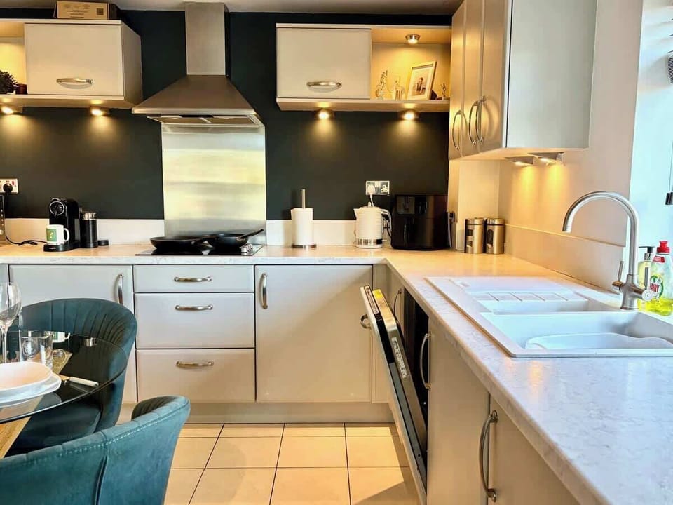 Modern kitchen in York city centre apartment with dining for two, stainless appliances, and easy walk to York Minster and restaurants.