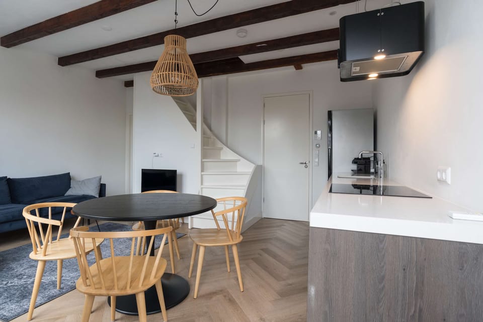 Authentic wooden ceiling beams meet modern design in this welcoming living area.