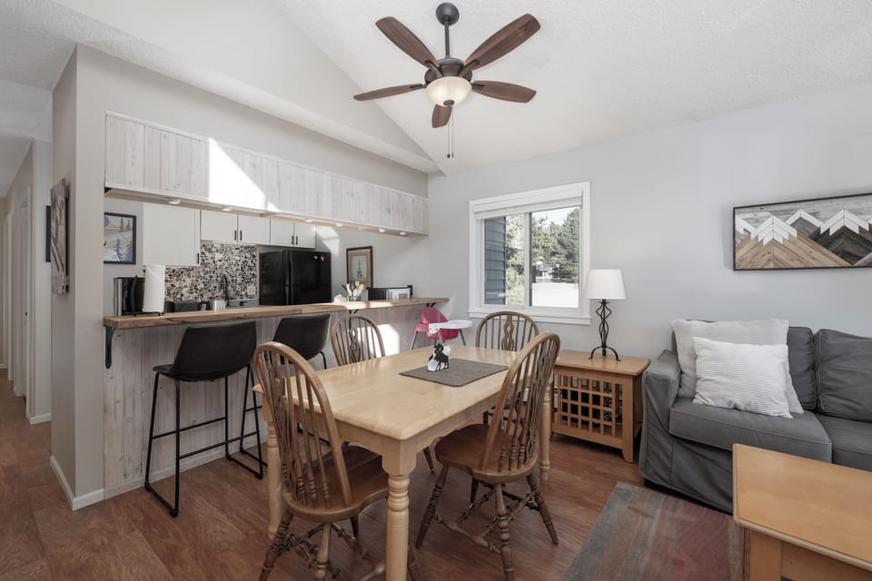 Your open-concept living space blends comfort with functionality—relax on the plush sofa, share meals at the wooden table, and create culinary memories in your well-equipped kitchen.