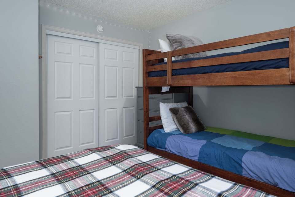 Your kids will love this cozy bunk bed room with plaid bedding and starlit ceiling—perfect for creating magical bedtime memories together.