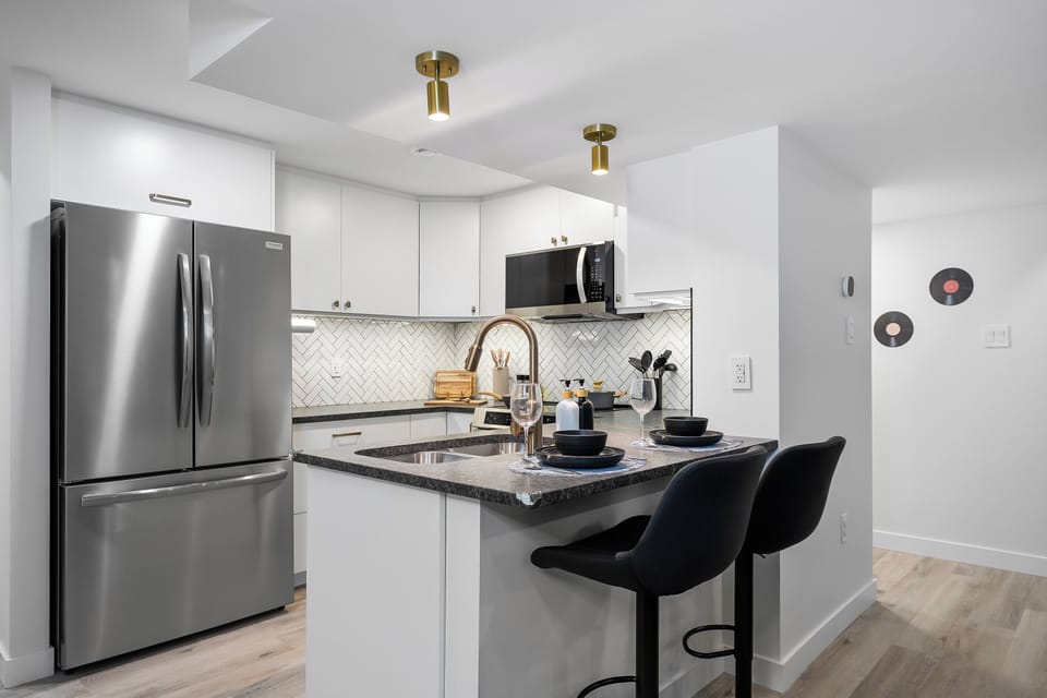 Fully equipped modern kitchen with stainless steel appliances, spacious countertops, and a cozy breakfast bar for easy meals and conversation