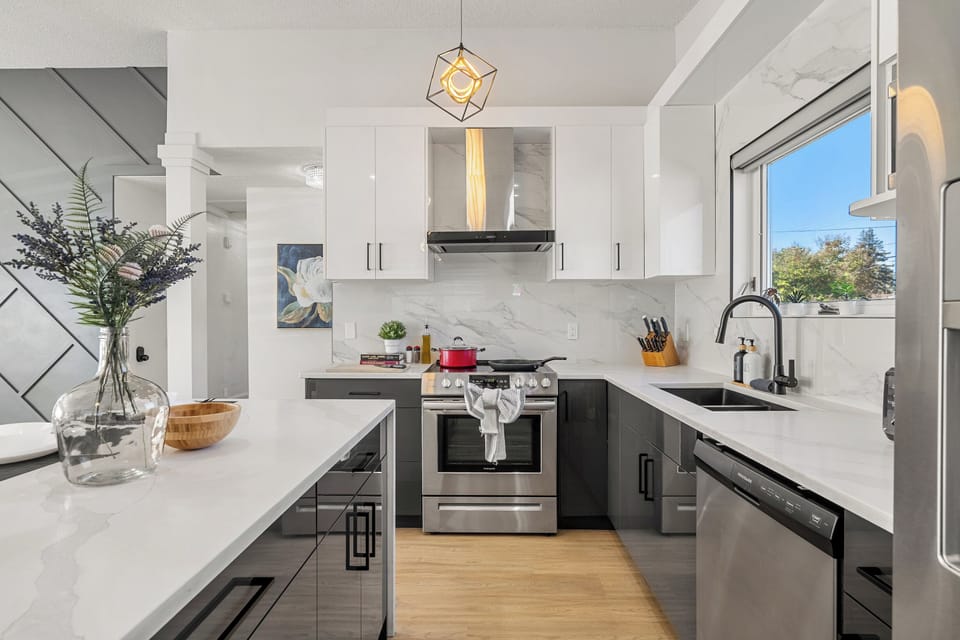 Sleek modern kitchen with white cabinets and stainless appliances.