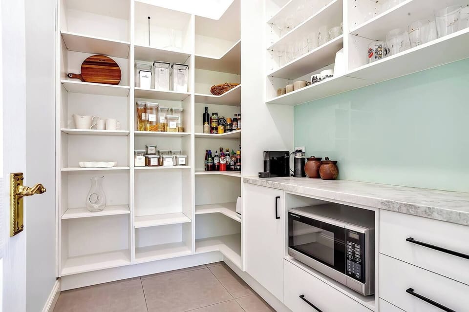 The generous pantry provides organised storage, a microwave, coffee station and ample supplies to make cooking effortless throughout your stay.